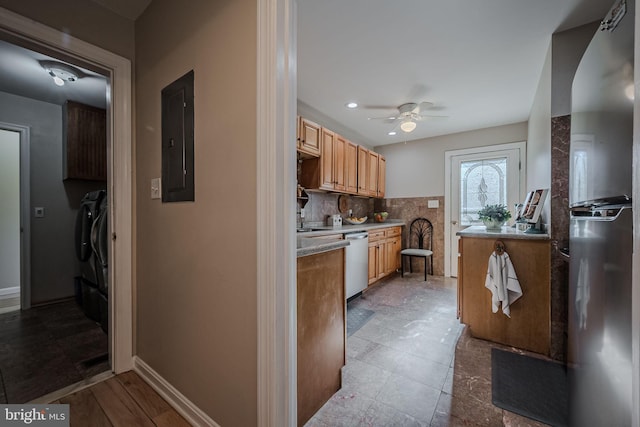 kitchen featuring ceiling fan, stainless steel appliances, electric panel, washer and dryer, and backsplash