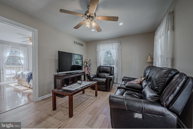 living room with light hardwood / wood-style flooring and ceiling fan