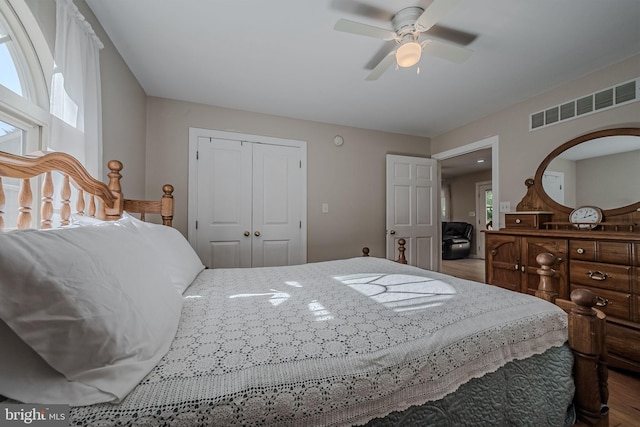 bedroom with ceiling fan, a closet, and wood-type flooring