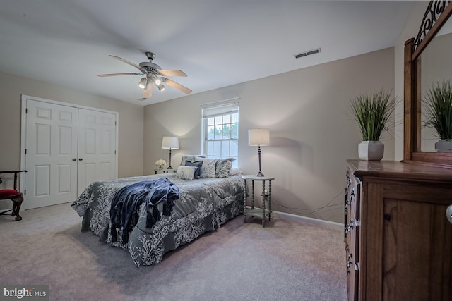 bedroom with ceiling fan, a closet, and light carpet