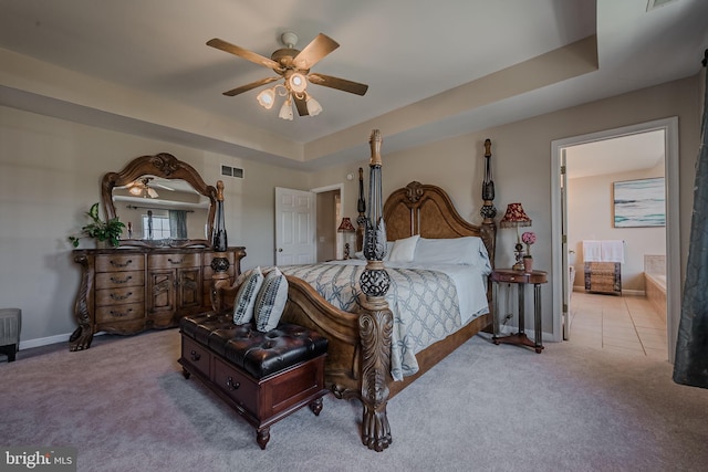 bedroom featuring ceiling fan, a raised ceiling, and light colored carpet