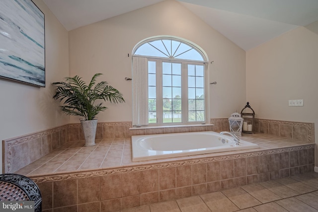 bathroom featuring lofted ceiling, tile patterned floors, and tiled bath