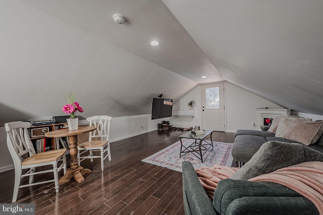 living area featuring dark wood-style flooring, baseboards, and lofted ceiling