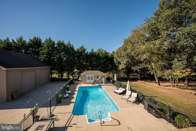 view of swimming pool with a patio and an outbuilding