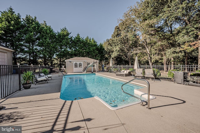 view of pool with a storage unit and a patio area