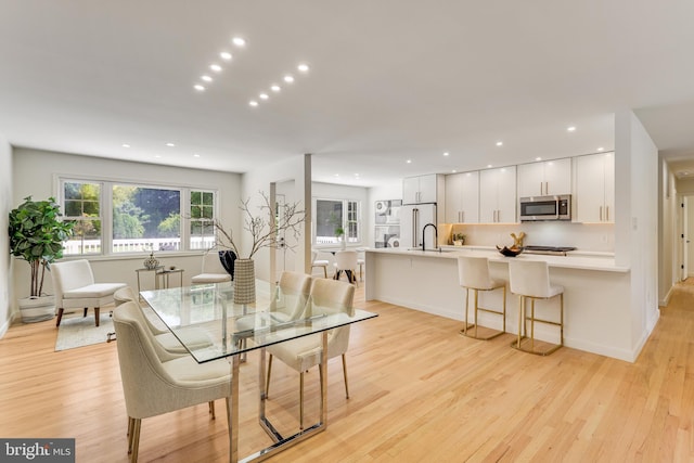 dining area featuring sink and light hardwood / wood-style floors