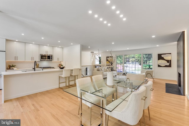 dining room featuring sink and light hardwood / wood-style flooring