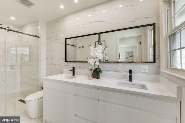 bathroom with vanity, toilet, an enclosed shower, and tile walls