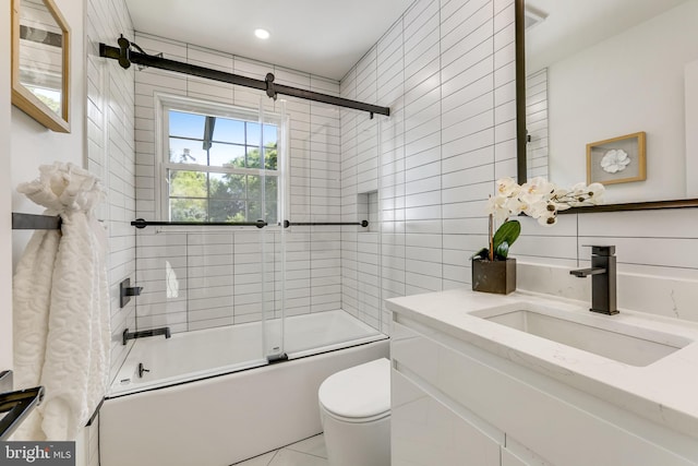 full bathroom featuring vanity, toilet, tile patterned flooring, and bath / shower combo with glass door