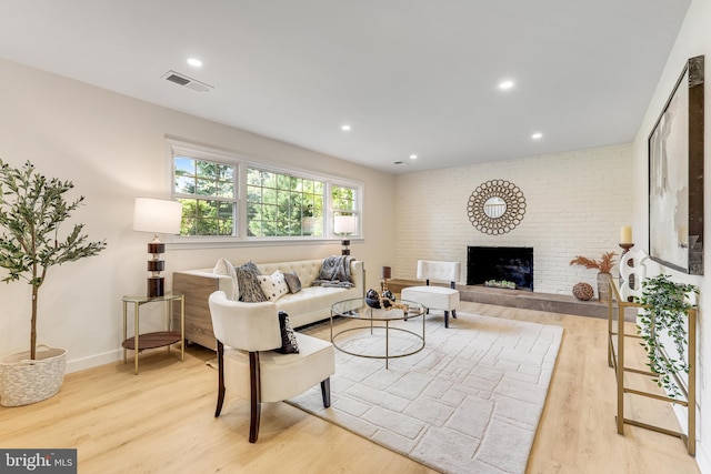 living room featuring light wood-type flooring and a fireplace