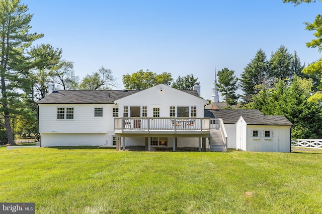 back of property with a lawn, a shed, and a deck