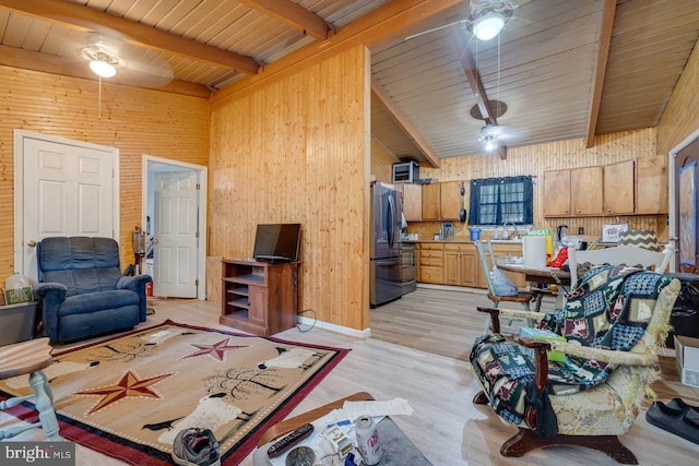 living room with wood walls, ceiling fan, wooden ceiling, beam ceiling, and light hardwood / wood-style floors