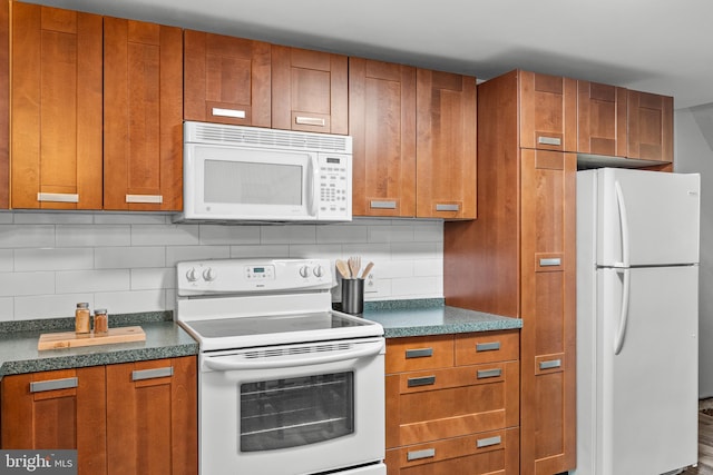 kitchen featuring backsplash, white appliances, and hardwood / wood-style flooring