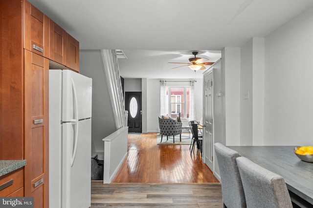 kitchen with ceiling fan, white fridge, and light hardwood / wood-style floors