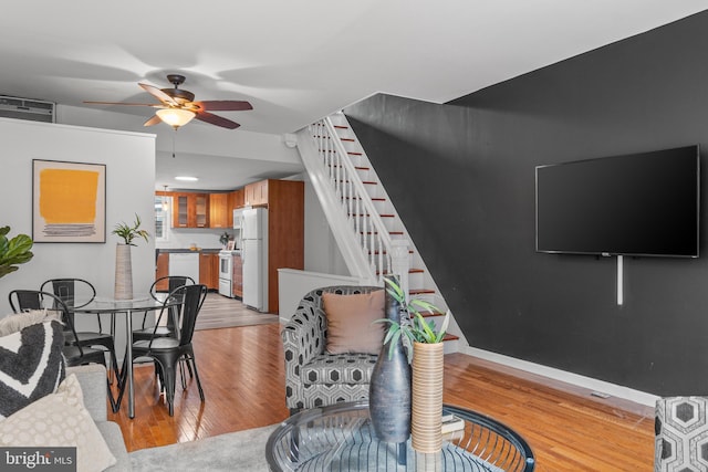 living room featuring ceiling fan and light hardwood / wood-style floors