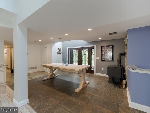 rec room with baseboards, visible vents, stone tile flooring, and french doors