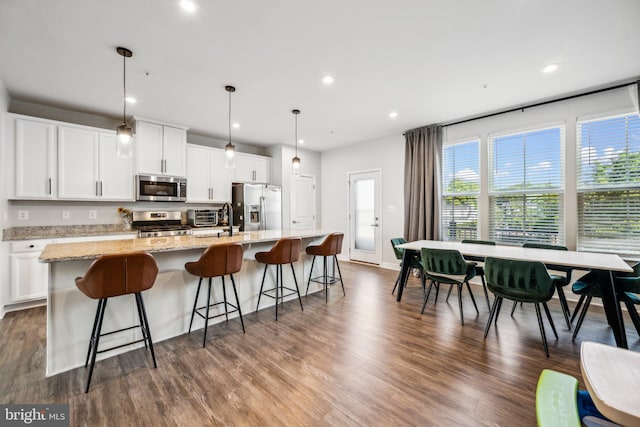 kitchen with a center island with sink, appliances with stainless steel finishes, and white cabinetry