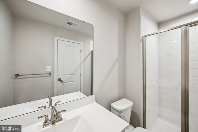 bathroom featuring vanity, an enclosed shower, and toilet