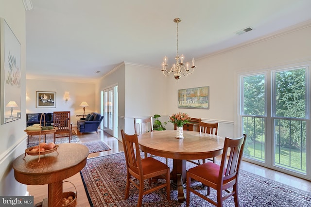 dining room featuring crown molding, hardwood / wood-style floors, and a chandelier