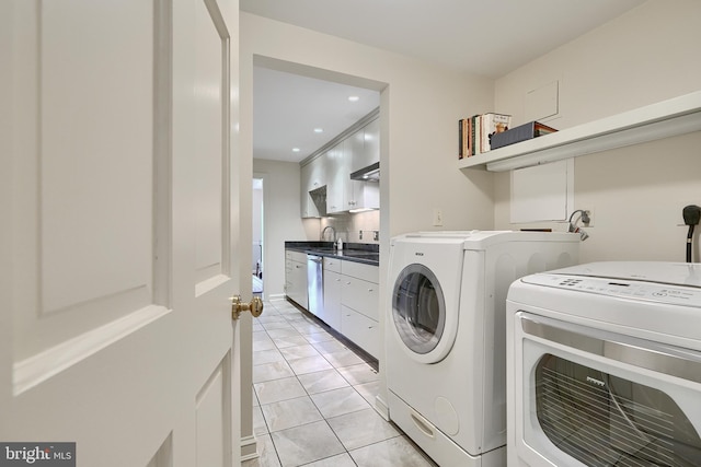 laundry room with washing machine and clothes dryer, light tile patterned floors, recessed lighting, a sink, and laundry area