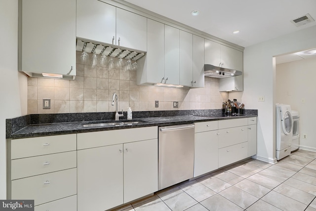 kitchen with under cabinet range hood, a sink, visible vents, stainless steel dishwasher, and washer and clothes dryer