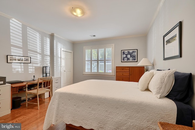 bedroom with light wood-type flooring, visible vents, and crown molding