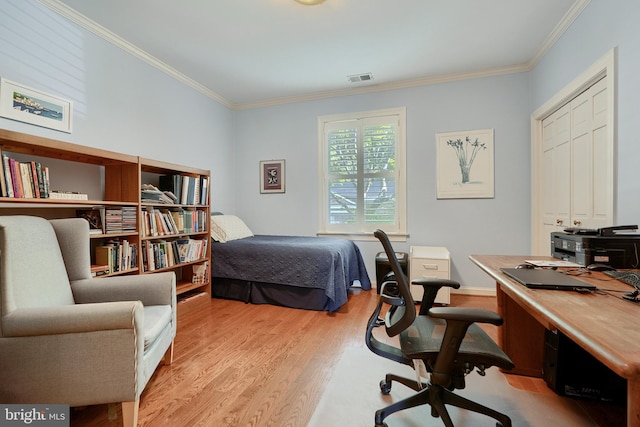 bedroom with light wood finished floors, visible vents, and crown molding