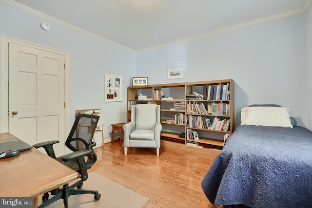 bedroom with baseboards, ornamental molding, and wood finished floors