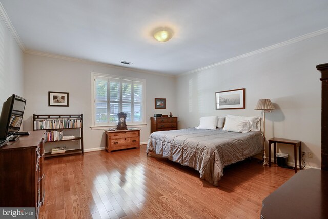 bedroom featuring crown molding and hardwood / wood-style flooring