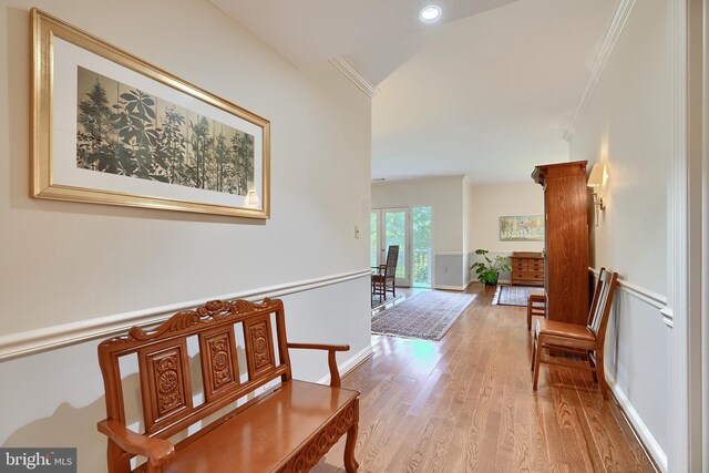 hallway featuring crown molding and light hardwood / wood-style floors