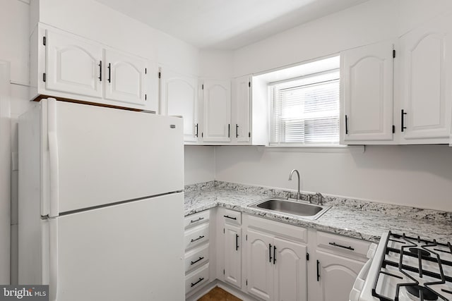 kitchen with sink, white appliances, and white cabinets