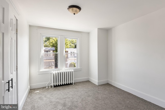 carpeted empty room featuring radiator