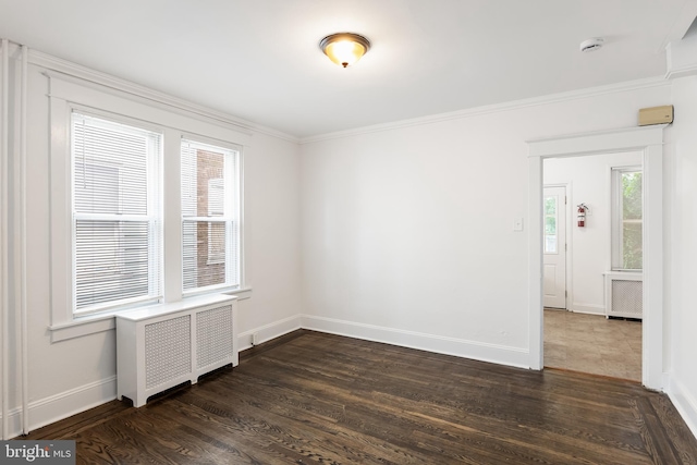 unfurnished room featuring dark wood-type flooring, radiator heating unit, and ornamental molding