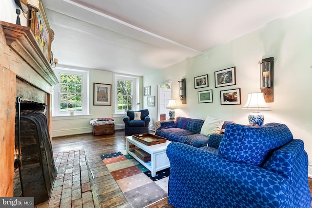 living area featuring baseboards, a fireplace, and hardwood / wood-style floors