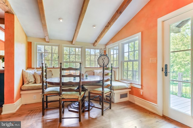 dining space featuring baseboards, vaulted ceiling with beams, visible vents, and hardwood / wood-style flooring