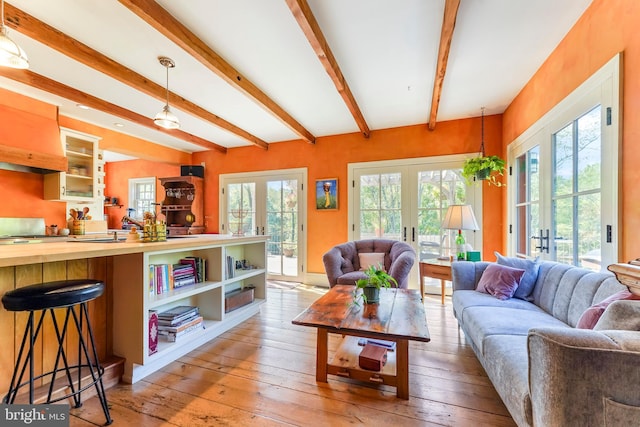 living room featuring a healthy amount of sunlight, light wood-type flooring, and french doors