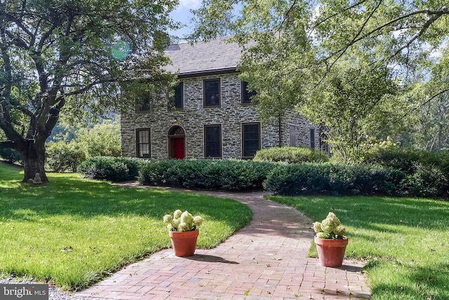 view of front of property with stone siding and a front lawn