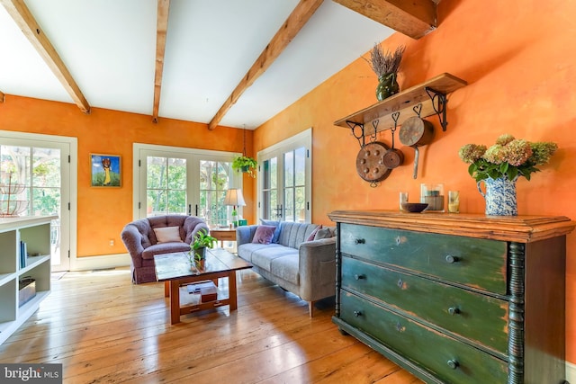 living room featuring beam ceiling, hardwood / wood-style flooring, and a healthy amount of sunlight