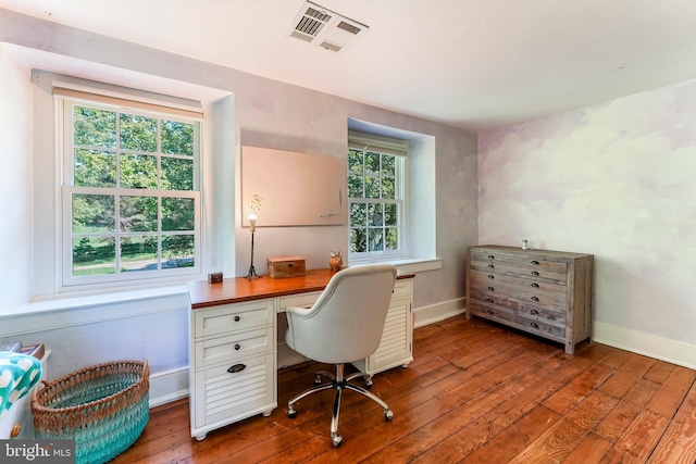 home office with a wealth of natural light, visible vents, baseboards, and wood-type flooring