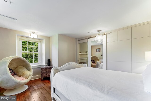 bedroom with dark wood-type flooring