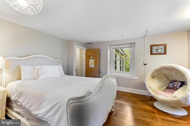 bedroom featuring hardwood / wood-style flooring and baseboards