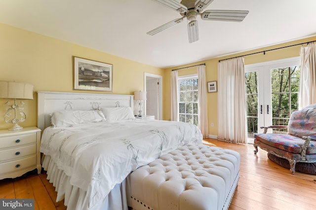 bedroom with multiple windows, light wood-style flooring, ceiling fan, and access to outside