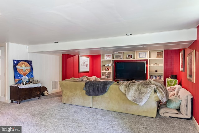 carpeted living room with beamed ceiling