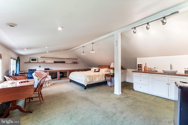 bedroom featuring light carpet, vaulted ceiling, track lighting, and sink