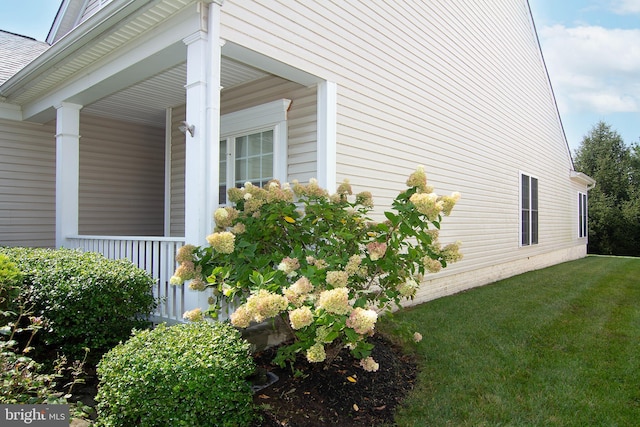 view of property exterior with a porch and a lawn