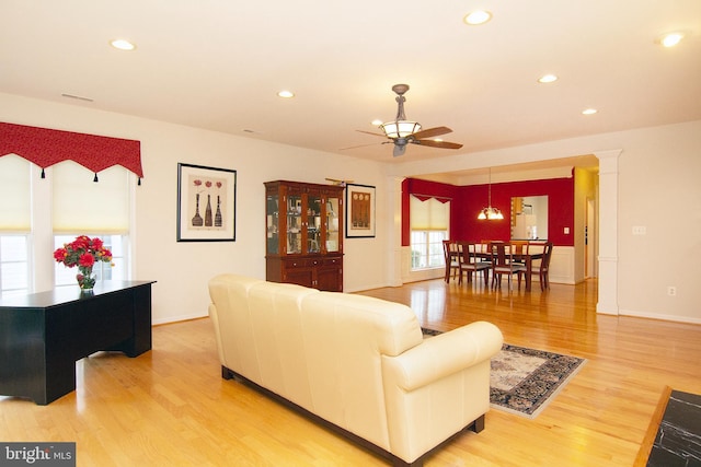 living area with light wood finished floors, a ceiling fan, and recessed lighting