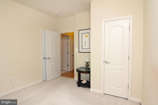 bedroom with light carpet and baseboards