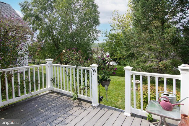 wooden deck featuring a lawn