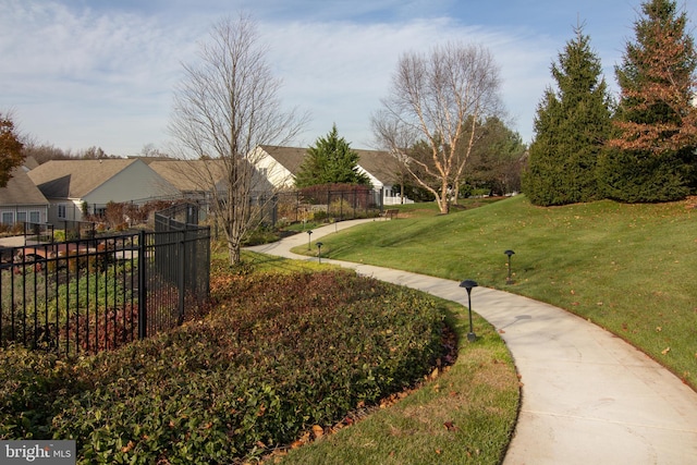 exterior space featuring a residential view, a lawn, and fence