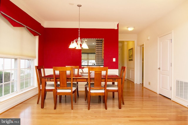 dining room featuring light hardwood / wood-style flooring, ornamental molding, and a chandelier